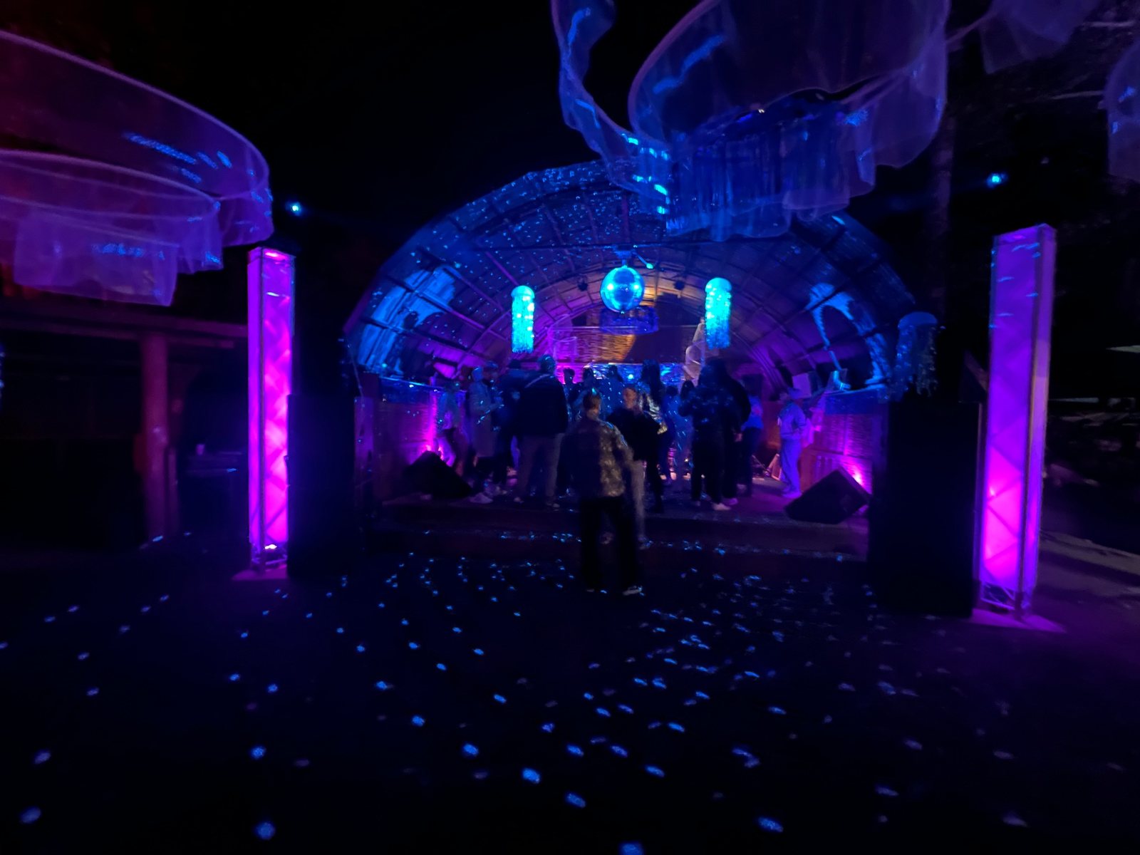 Die Festivalbühne mit bunten Lichtinstallationen bei Nacht